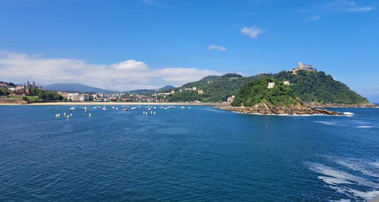 Vue panoramique de la baie avec voiliers et une forteresse au sommet de la colline verdoyante à San Sebastian.