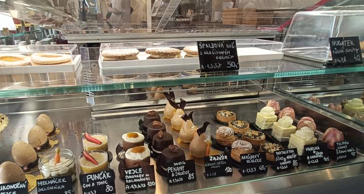 Glasvitrine mit assortierter Auswahl an Gebäck, Kuchen und tschechischen Süßspeisen in einer Bäckerei.
