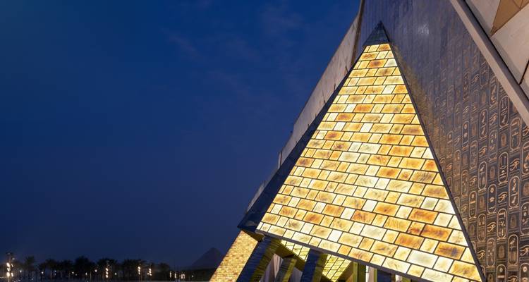 Close-up of an illuminated pyramid-shaped wall at night.