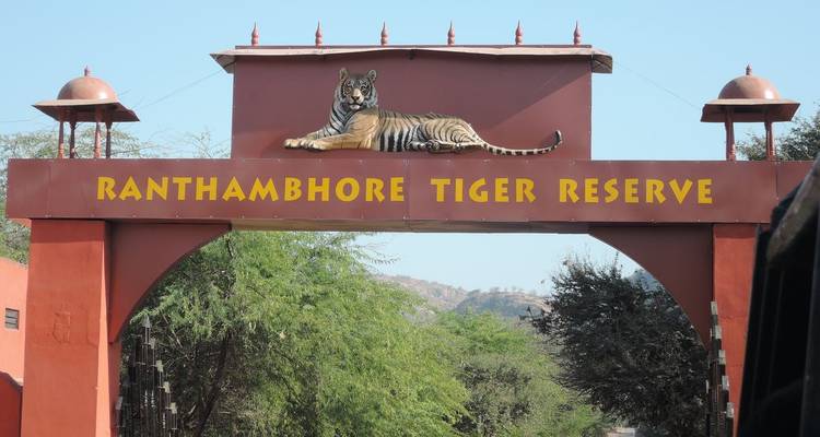 Entrance archway to Ranthambhore Tiger Reserve topped by a reclining tiger sculpture.