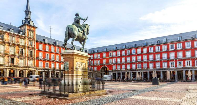 Estatua de Felipe III en la Plaza Mayor de Madrid rodeada de edificios históricos de fachada roja