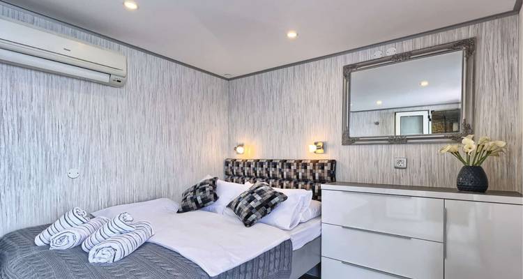 Interieur van een jachthut met een tweepersoonsbed en modern design.