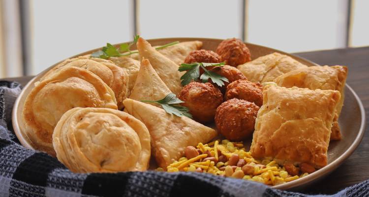 Platte mit assorted herzhaften Gebäcksorten und frittierten Snacks auf einem Tisch im Innenraum angeordnet