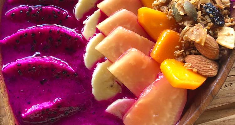 Colorida bandeja de frutas tropicales con fruta del dragón, papaya, plátano y frutos secos