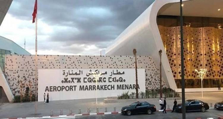 Modern façade of Marrakech Menara Airport with Arabic and Latin signage under overcast skies