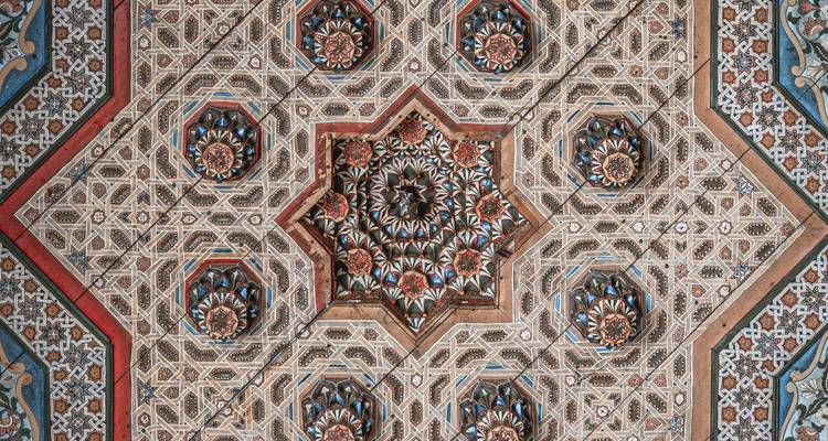 Intricate geometric and floral ceiling pattern of Moroccan craftsmanship in vibrant colors