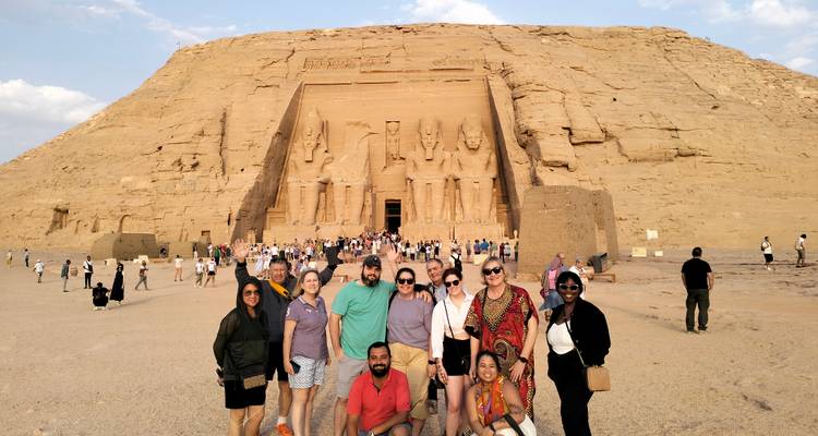Groupe de touristes posant devant l'entrée d'un grand temple.