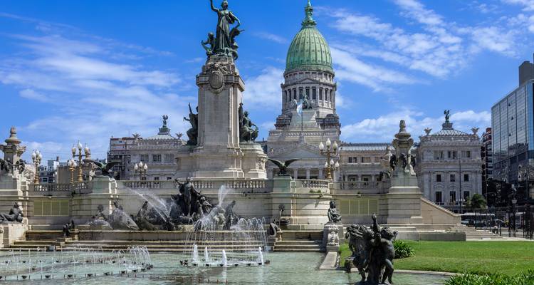 A grand historic building with a fountain and statues.