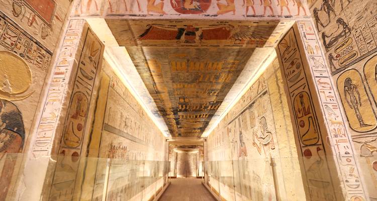Hallway with hieroglyphs leading to a brighter area.