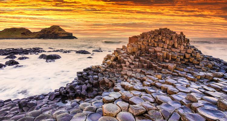 Basalt columns forming natural stepping stones beside the sea.