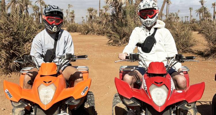 Two people on quad bikes in a desert landscape.