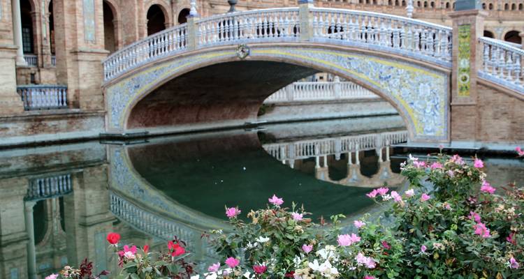 Decorative bridge over a canal with flowers.