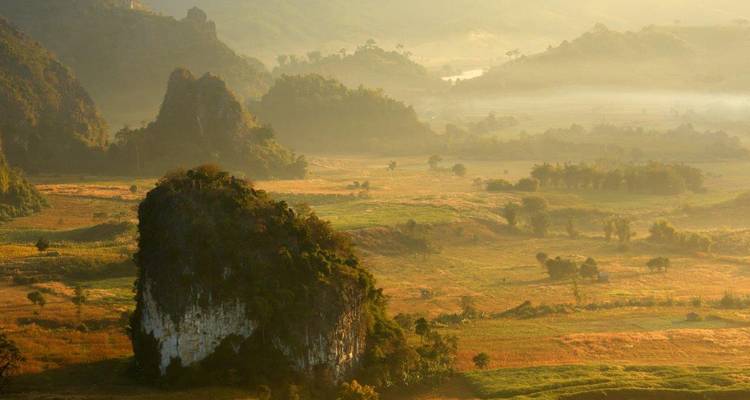 Paysage pittoresque avec des collines couvertes de brume au lever du soleil.