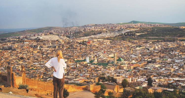 A person overlooking the city of Fes from a high viewpoint.