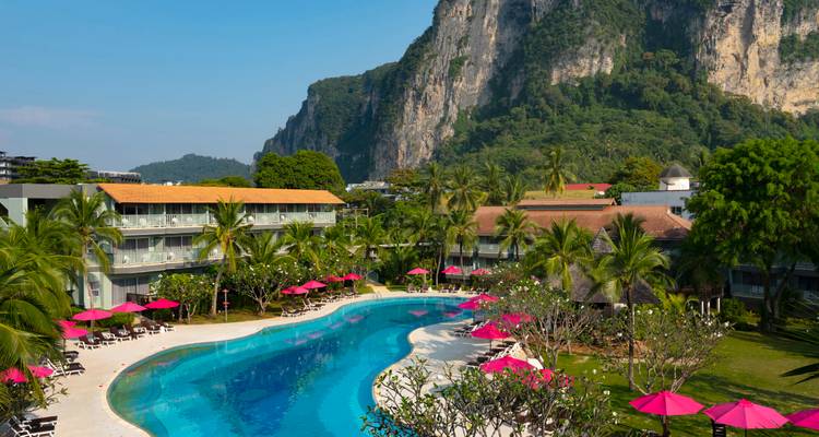 Un complexe hôtelier luxueux avec une grande piscine et un décor de montagnes.