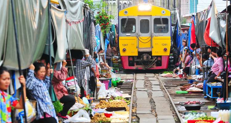 Train passant à travers un marché bondé.
