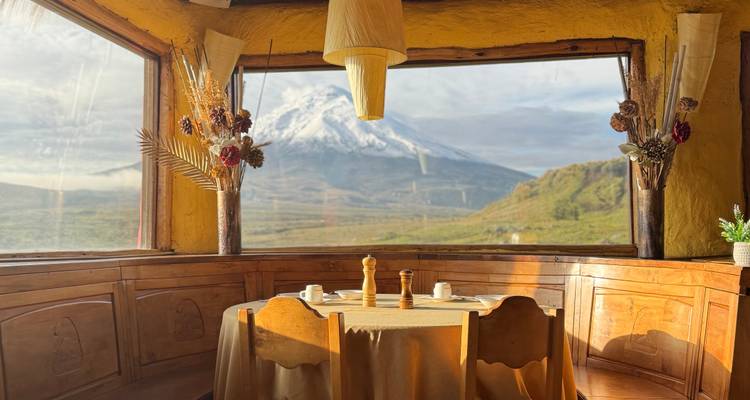 Comedor rústico con vista a una montaña nevada.