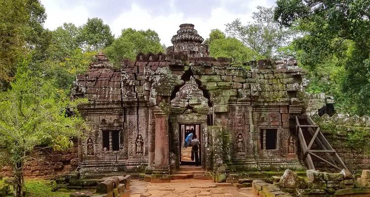 Ancien temple de pierre niché dans un cadre forestier luxuriant.