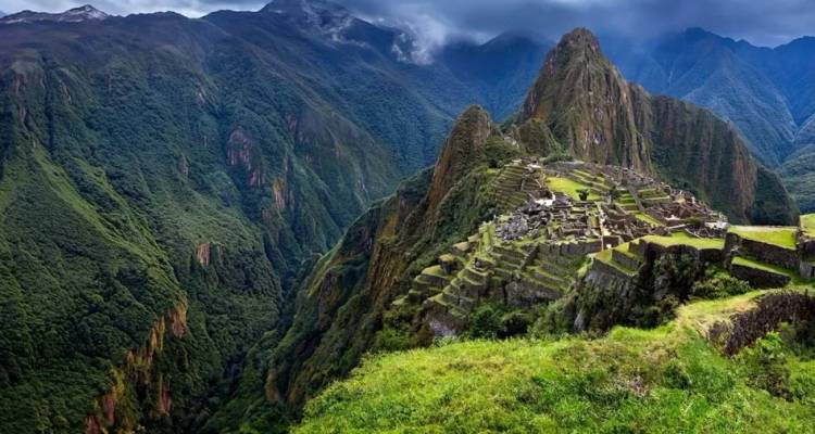 The Incan citadel of Machu Picchu sits atop a lush ridge surrounded by steep Andean peaks.