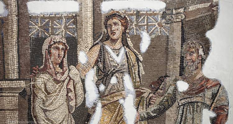 Mosaico antiguo fragmentado que representa figuras, con secciones faltantes que revelan la superficie de soporte.