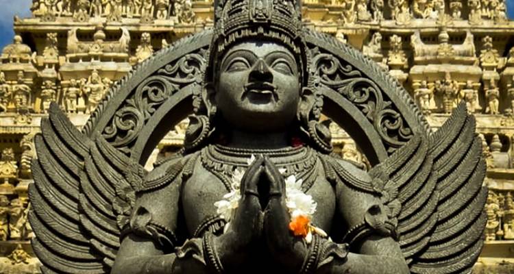 Sculpture of a deity with folded hands.