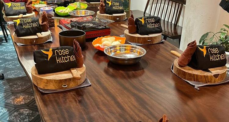 Table setting with cooking materials and branded aprons in a kitchen.