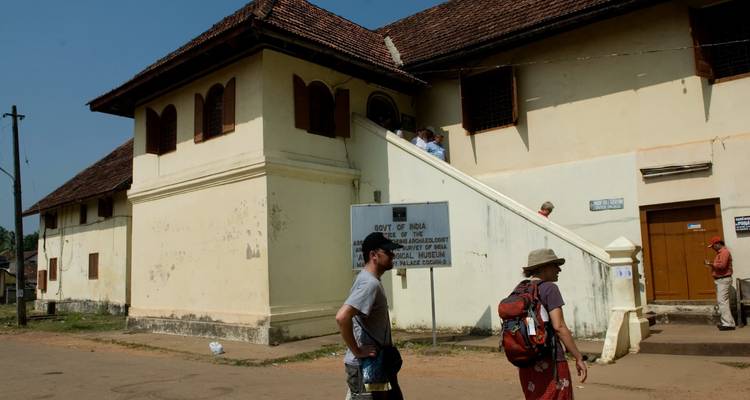 Tourists exploring a historical museum building with signage.