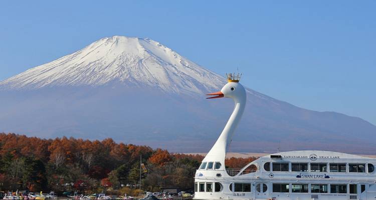 A swan-shaped boat on a lake with Mount Fuji visible in the distance.