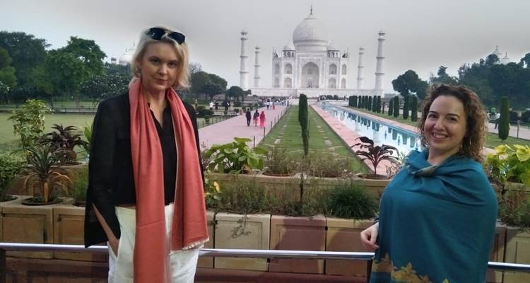 Two women posing with the Taj Mahal in the background.