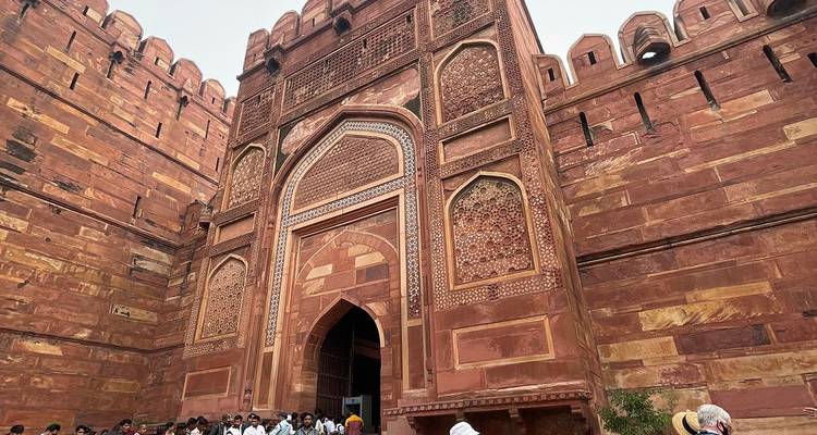 Entrance of a historical fort in Agra with tourists.