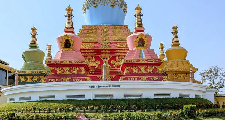 Vibrant multicoloured Tibetan stupa with ornate dragons and lions on white plinth
