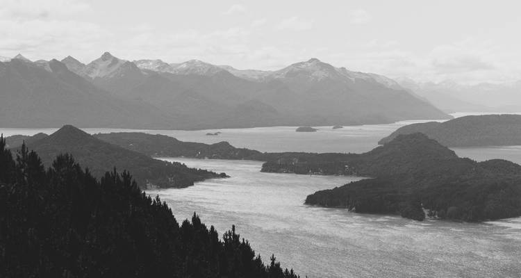Black and white photo of a lake with surrounding mountains, possibly in Patagonia.