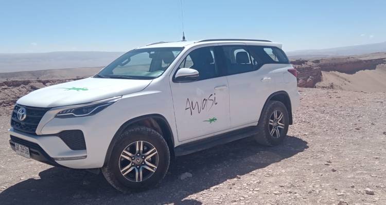 4x4 vehicle in a desert area with a mountain backdrop, possibly in Atacama Desert.