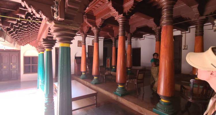People inside a traditional building with wooden columns.