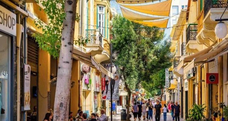 Lively pedestrian street with cafes, shops and hanging shades in a historic Cypriot town
