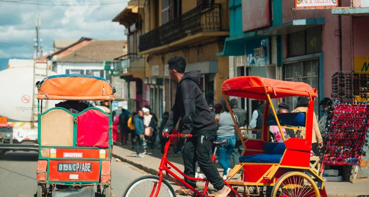 Bustling street scene with rickshaws and people in Madagascar.