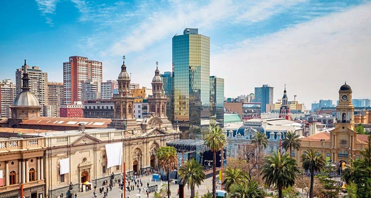 Cityscape with historic and modern buildings under blue skies.