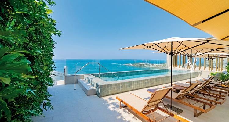 Liegestühle und Sonnenschirme mit Blick auf das Meer.