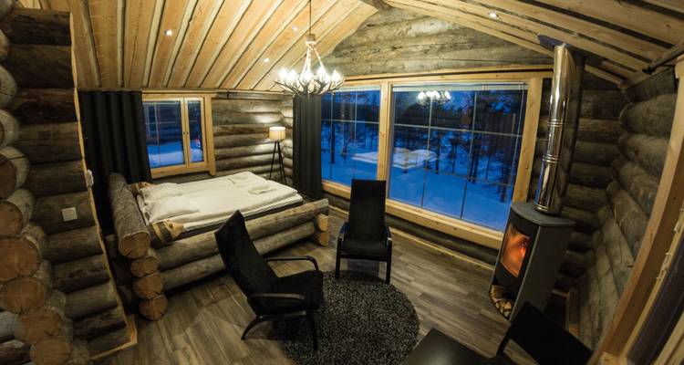 Gemütliches Hütteninterieur mit einem Bett und einem Kamin.