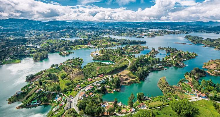 Aerial view of lakes and green islands in a mountainous landscape.