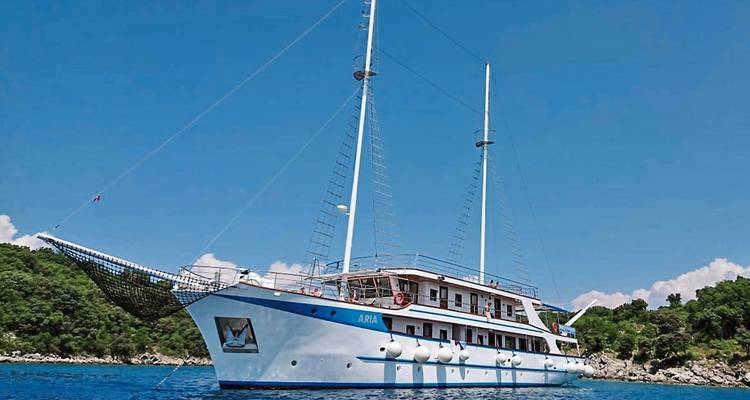 Elegante yate blanco con dos velas en mar abierto.