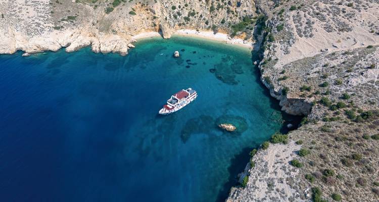 Vue aérienne d'un bateau dans une baie isolée aux eaux claires.
