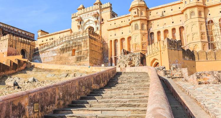 Stenen trap die omhoog leidt naar de massieve wallen van Amber Fort onder blauwe lucht.