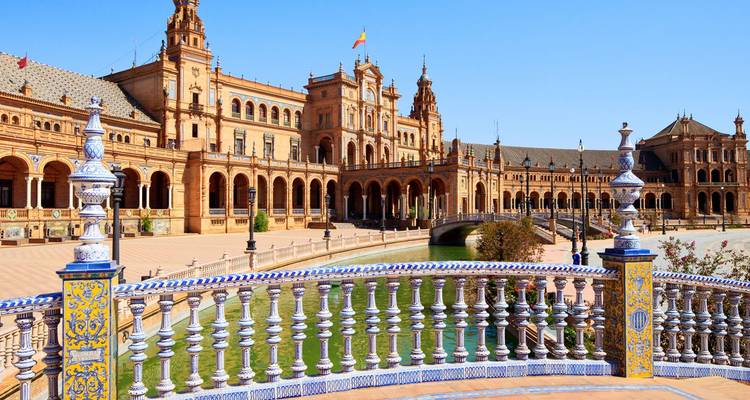 Weitläufige Ansicht des großartigen Plaza de España mit seinem kunstvollen Balustrade, gewölbten Brücken und weitläufigem Platz unter klarem blauem Himmel