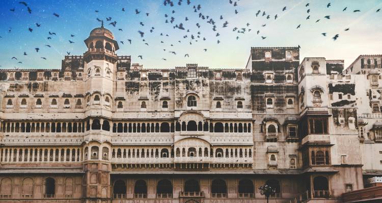 Grand fort historique avec des oiseaux qui volent au-dessus.