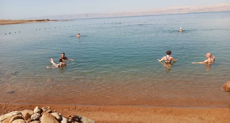 Des gens flottant et nageant dans un lac calme.