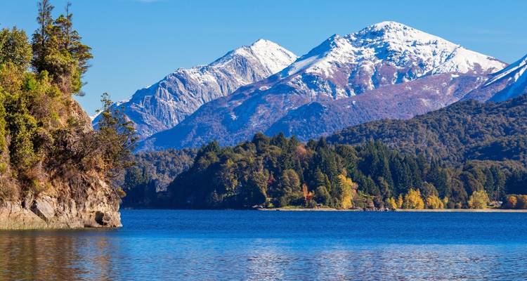 Montañas cubiertas de nieve con lago en primer plano.