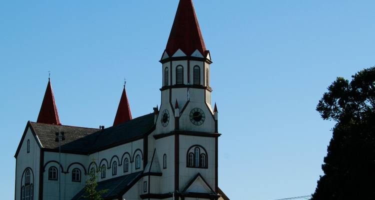 Iglesia histórica con tejados rojos y un cielo despejado.