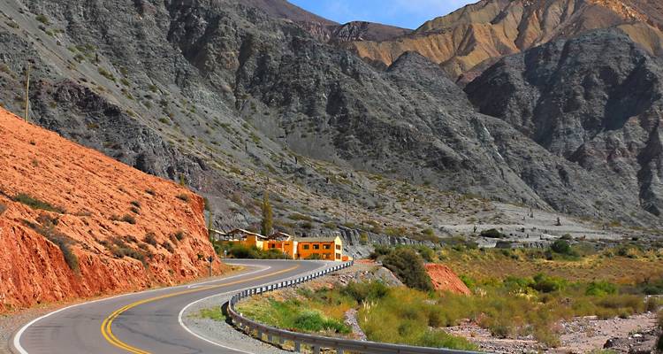 Schilderachtige weg die door een bergachtig landschap kronkelt.