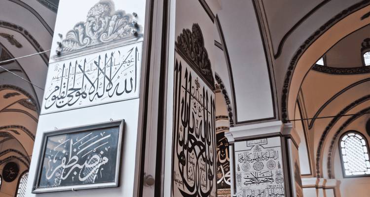 Grandes paneles de caligrafía árabe que decoran las columnas interiores de la Gran Mezquita de Bursa.